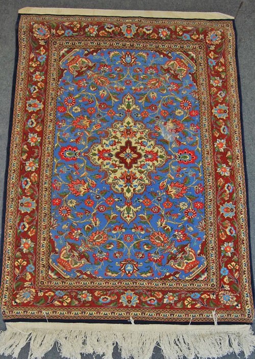 * A modern Persian Kashan style rug, the blue ground field centred with a foliate lozenge within