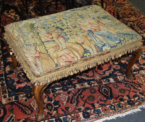 An early 18th Century style walnut footstool, having tapestry woven stuff-over top depicting figures