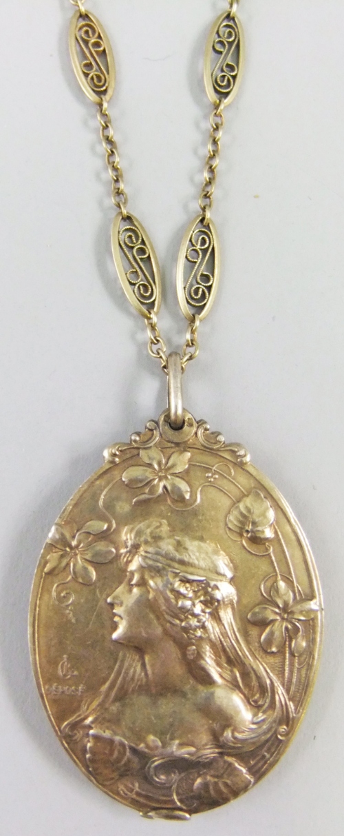 A French Art Nouveau silver gilt mirror locket and chain. The oval locket depicting a maiden in