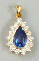 An 18ct yellow and white gold diamond and sapphire pendant, the tear drop shape sapphire approx 3.