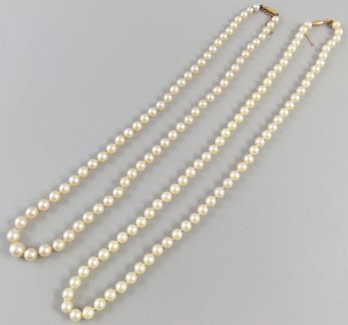 A cultured pearl necklace with gold clasp 53.5cm together with another similar 58.5cm. (2)