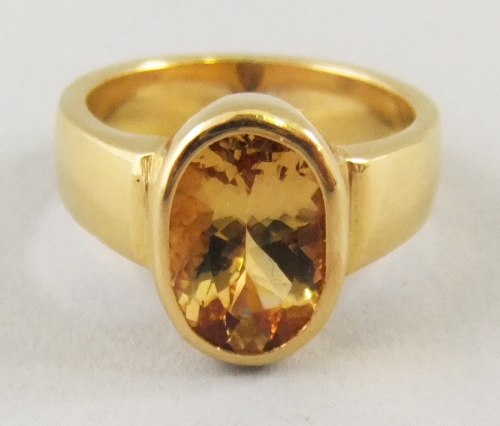 A 22ct gold and yellow topaz ring, the oval topaz bezel set, stamped 916 approx gross weight 10.7g