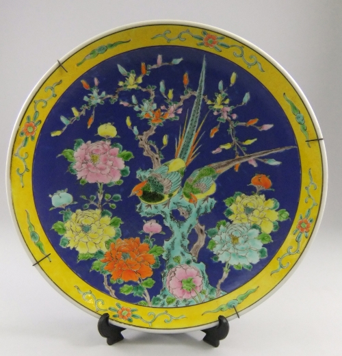 A Chinese famille jaune wall plate, 20th century, central birds amidst flowering foliage over blue