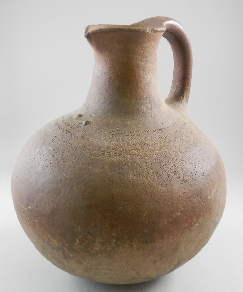 * A large African clay jug, possibly Luba tribe, of classical form and brown colour, with continuous