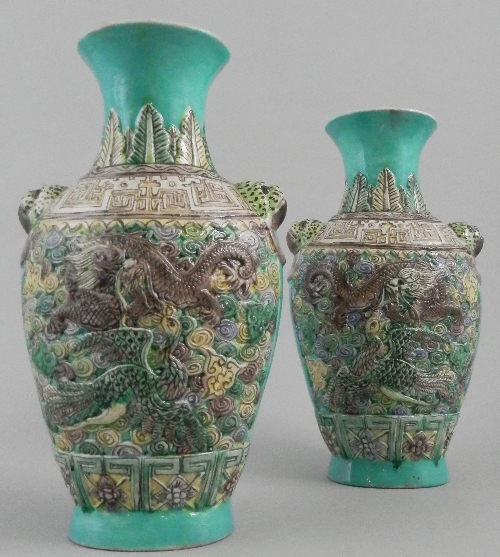 A pair of Chinese three colour baluster vases, 19th century, relief decorated panels depicting