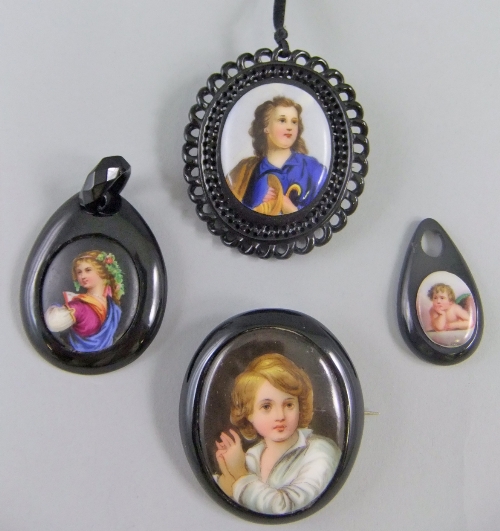 A collection of 4 19th century jet pendants and brooches, each set with a porcelain miniature, two