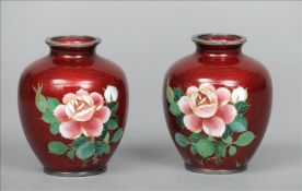 A pair of Chinese unmarked silver and cloisonne vases Each with a flowering rose on a deep red
