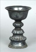 A 19th century Tibetan unmarked silver goblet The flared rim with a band of cast lappet decoration