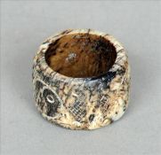 A Chinese carved white and black jade archers ring Of circular section with incised decoration. 3.25