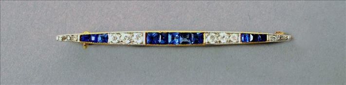 An Art Deco style unmarked gold, diamond and sapphire bar brooch 5.5 cms wide. Overall good, some