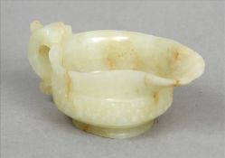 A 19th century Chinese mutton fat jade carving In the form of a small archaic vessel. 10 cms wide.