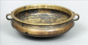 A Chinese bronze twin handled censor The body with moulded rim and applied decoration, standing on