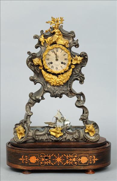A 19th century French ormolu and silvered automaton mantle clock The scroll cast case mounted with