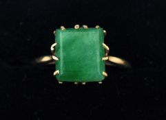 A jade set gold ring Of claw set canted square form, marks indistinct. Some general wear, scuffing/