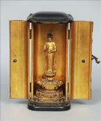 A 19th century cased Sino-Tibetan shrine figure The removable carved giltwood statue modelled wear