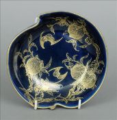 A Chinese porcelain leaf form dish Decorated in gilt with bats amongst fruiting sprays on a blue