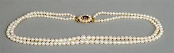 A two string pearl necklace Mounted with an amethyst set 9 ct gold clasp. Approximately 42 cms long.