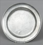 An 18th century pewter charger The banded rim above the central dished recess, the reverse with