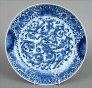 A Chinese porcelain blue and white charger The centre extensively decorated with dragons chasing a