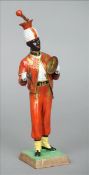 A Dresden porcelain figure entitled Jean Baptise Time Beater 1840 Modelled as a Negro gentleman