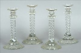 A set of four 19th century clear cut glass candlesticks Each drip-pan of rounded castellated form