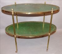 A leather topped brass framed two tier etagere The gilt tooled leather inset oval top with brass