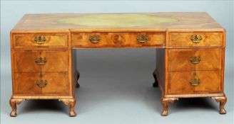 An early 20th century burr walnut pedestal partner`s desk The oval leather inset shaped