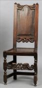 A 17th century oak panel back hall chair The carved pierced top rail above a shaped panelled back
