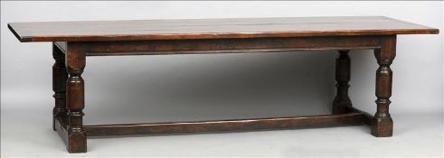 An 18th century style oak refectory table The cleated plank top above a plain frieze, standing on