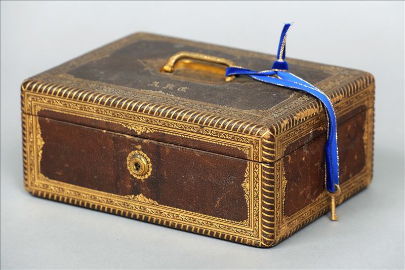 A Victorian tooled leather jewellery box The hinged rectangular lid with an inset brass loop handle,