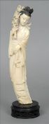 A Chinese carved ivory figure of Guanyin Modelled in flowing robes holding a stem of flowers,