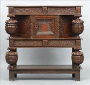 A 17th century and later joint oak open court cupboard Above a deep frieze with carved floral