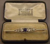 An Art Deco unmarked gold, platinum, sapphire and diamond bar brooch The navette shaped pierced