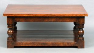 A large modern oak coffee table The planked square section top above a plain frieze supported on