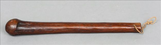 A carved hardwood tribal club, possibly Hawaiian The end drilled for suspension loop. 46 cms long.
