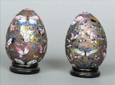 A pair enamel decorated unmarked white metal eggs Each decorated throughout with various butterflies