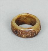 A Chinese carved green and russet jade archers ring Of circular section with incised decoration. 3.5