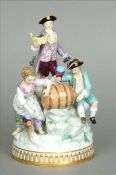 An early 20th century Meissen figural group Depicting revellers decanting wine from a barrel. 21 cms