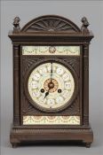 A 19th century bronze and enamel mantle clock The finial mounted domed top above a panel of swag