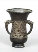 An archaistic style Chinese bronze vase The shaped flared rim above twin mask headed loop handles