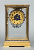 A 19th century French brass cased four glass clock The circular dial with Arabic numerals and enamel