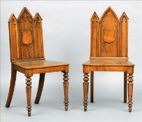 A pair of Victorian Gothic Revival pollard oak hall chairs Each back of architectural form with a