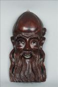 An early 20th century Chinese carved hardwood wall mask, possibly Shou-Lao Modelled with inset glass