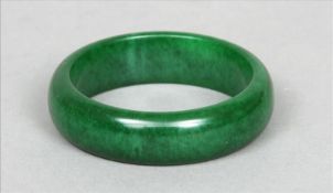 Two jade bangles One of deep apple colour, the other paler. The former 7.5 cms diameter. (2) Some