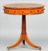 A satinwood drum table The leather inset top above an arrangement of drawers and dummy drawers,