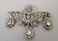 A Continental silver paste inset brooch Of scrolling floral form with three pendant drops, the