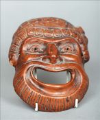 A Japanese pottery mask of Noh Typically modelled with allover brown glaze. 12.5 cms wide.