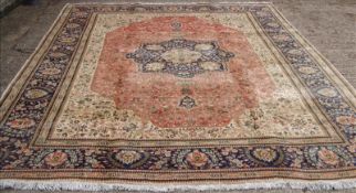 A Tabriz wool carpet The wine red field enclosing a central medallion with pendant palmettes