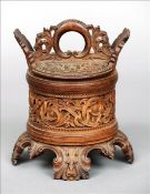 A 19th century Continental carved wood tobacco pot The removable lid between scroll carved