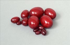 A small quantity of red amber beads Of varying sizes. The largest approximately 3.5 cms wide.